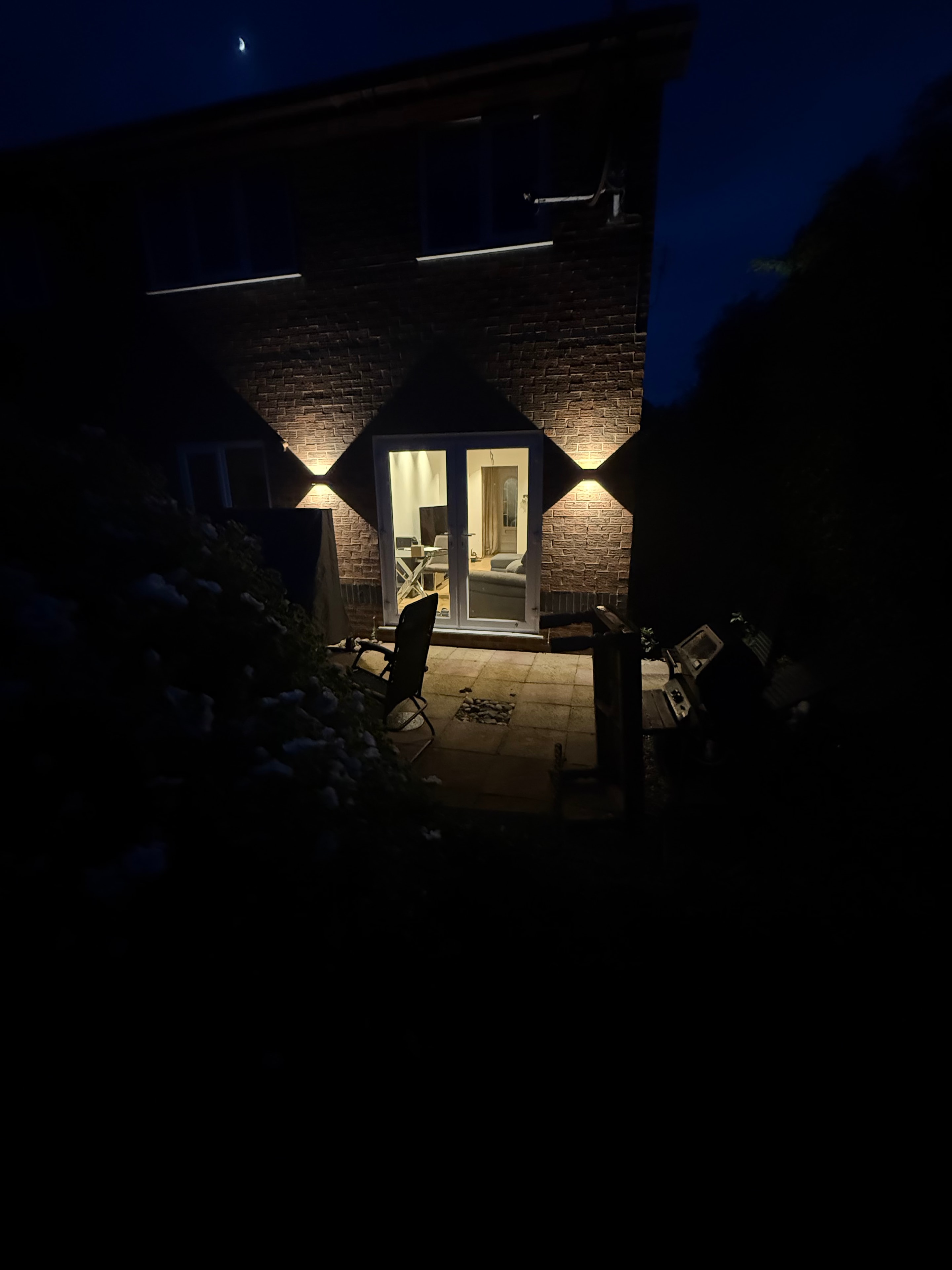 Exterior wall light casting warm glow on brick at night